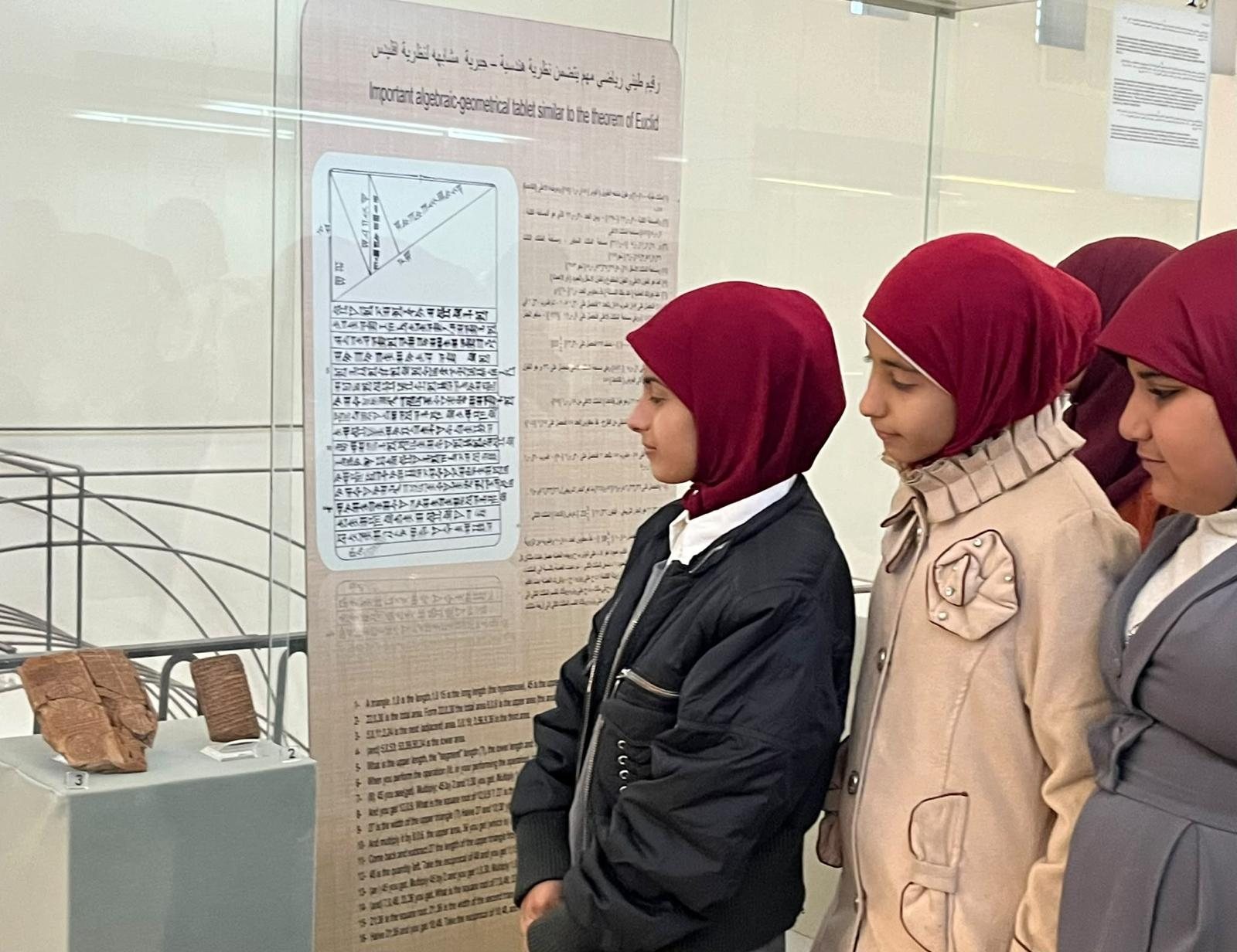 Schoolgirls at the Iraq Museum looking at an ancient Babylonian mathematical tablet