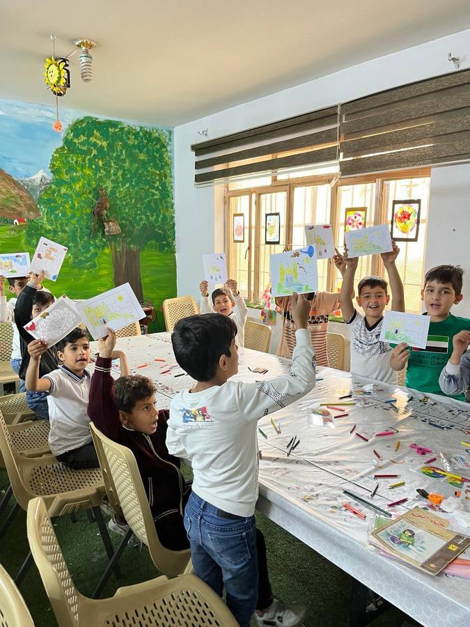 Children holding up their drawings in a workshop