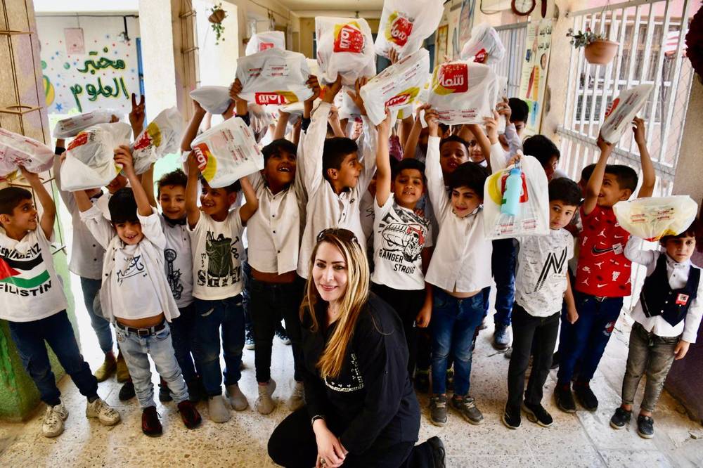 Children holding gift bags above their heads