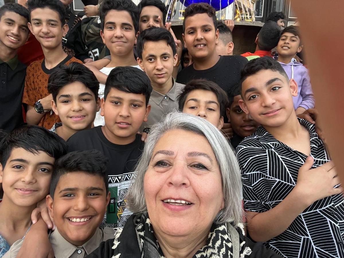 Khulood Da'mi taking a selfie surrounded by smiling boys