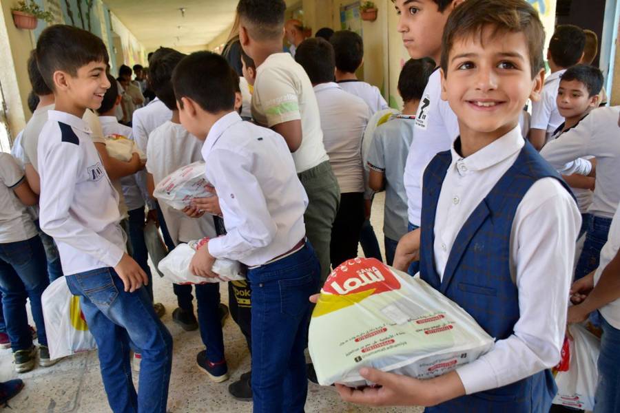 A smiling boy holding a gift at school